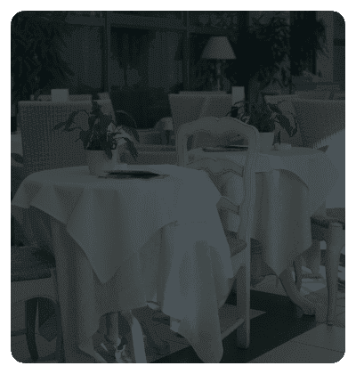 Elegant restaurant with white tablecloths and potted plants